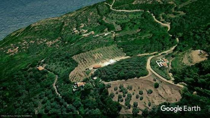 'Gripioti Farm' from above surrounded by trees and the sea in the background